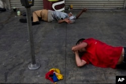 Lying on a urine-stained sidewalk, two homeless drug addicts hallucinate in Los Angeles' Skid Row area, home to the nation's largest concentration of homeless people, Sept. 1, 2017.