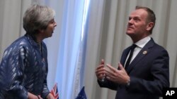 Le président du Conseil de l'Union européenne, Donald Tusk, à droite, s'entretient avec la première ministre britannique Theresa May lors d'une réunion bilatérale en marge du sommet des dirigeants européens et arabes au centre de conventions Sharm El Sheikh de Sharm El Sheikh, en