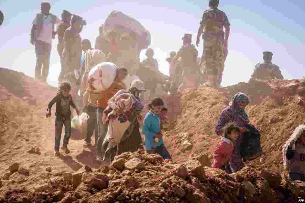 A handout picture released Aug. 29, 2014 by the United Nations High Commissioner for Refugees (UNHCR) shows Syrian refugees streaming across the border into Jordan at a remote border point in the east. 