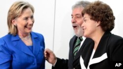 Hillary Clinton cumprimentando a presidente Dilma Rousssef e o antigo presidente Lula da Silva