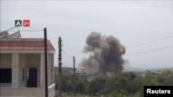 FILE - A barrel bomb dropped from a helicopter explodes in Karsaa, Idlib province, Syria, May 7, 2019, in this still image taken from a video on May 9, 2019.