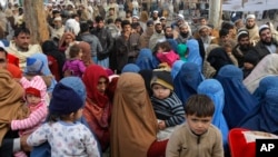 افغان پناہ گزین پشاور میں اپنے اندراج کے منتظر ہیں۔ فائل فوٹو
