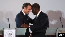 Le président français Emmanuel Macron (L) salue son homologue ivoirien, le président Alassane Ouattara, en marge d'une conférence de presse au Palais présidentiel à Abidjan le 21 décembre 2019.