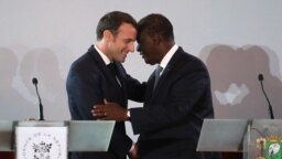 Le président français Emmanuel Macron (L) salue son homologue ivoirien, le président Alassane Ouattara, en marge d'une conférence de presse au Palais présidentiel à Abidjan le 21 décembre 2019.