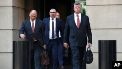 Miembros del equipo de defensa de Paul Manafort salen de la corte federal durante un receso del juicio all ex asesor de campaña de Donald Trump. 