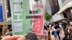 職工盟街站派發以中國異見藝術家艾未未”透視系列”為概念的透明小卡片，呼籲市民”揸緊宗旨”、決不投降(Never Surrender)。(美國之音湯惠芸拍攝)