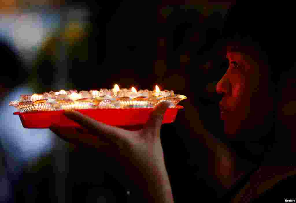 싱가포르의 석가탄신일인 &#39;베삭 데이&#39;를 맞아 &#39;콩멩산포르카르크시(Kong Meng San Phor Kark See)&#39; 승당에서 신자가 촛불을 들고 기도를 하고 있다.