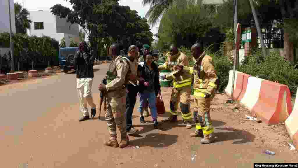 Les éléments de force de sécurité et les secours encadrent des personnes évacuées du lieu de l&#39;attaque de Bamako, Mali, 20 novembre 2015. (crédit : King Massasy)