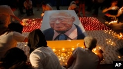 FILE - Members of the public light candles around a portrait of the late Lee Kuan Yew as a tribute to him, March 27, 2015, in Singapore. 