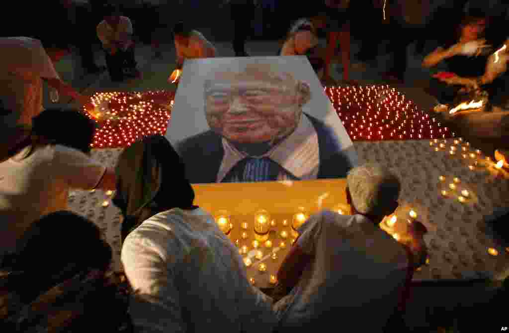 Members of the public light candles around a portrait of the late Lee Kuan Yew as a tribute to him, in Singapore. Lee, 91, died Monday at Singapore General Hospital after more than a month of battling severe pneumonia.