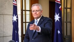 Australian Prime Minister Scott Morrison gestures during a press conference at Australia's Parliament House in Canberra on March 22, 2020. - Morrison told citizens to cancel any domestic travel plans to slow the spread of coronavirus, warning stronger mea