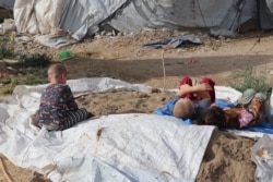 Foreign children in al-Roj camp pretend this pile of sand is a beach on Oct. 19, 2021 in al-Roj, Syria. (Heather Murdock/VOA)