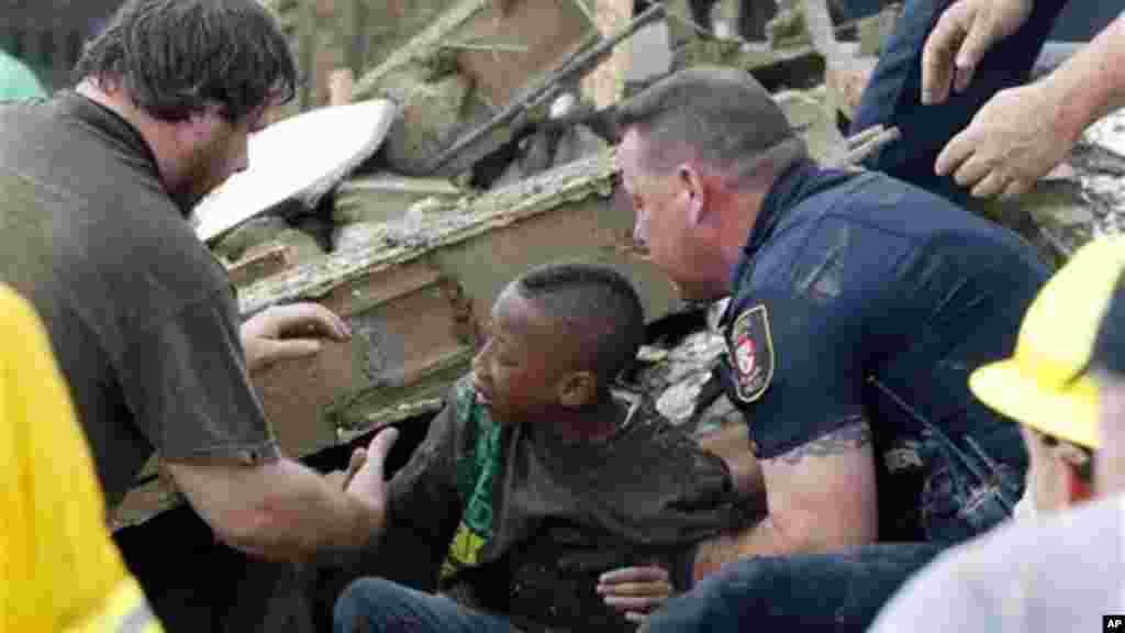 A boy is pulled from beneath a collapsed wall at the Plaza Towers Elementary School following a tornado in Moore, Okla., Monday, May 20, 2013.