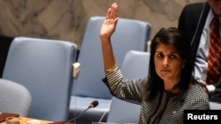 FILE - U.S. Ambassador to the U.N. Nikki Haley votes for a draft resolution condemning the reported use of chemical weapons in Syria at the Security Council meeting on the situation in Syria at the United Nations Headquarters in New York, April 12, 2017. 