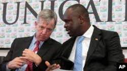 FILE - Anthony Banbury, left, outgoing head of the United Nations Mission for Ebola Emergency Response, speaks with Ghanaian Minister of Information Dr. Edward Omane Boamah during a press conference on Ebola, in Accra, Sept. 30, 2014.