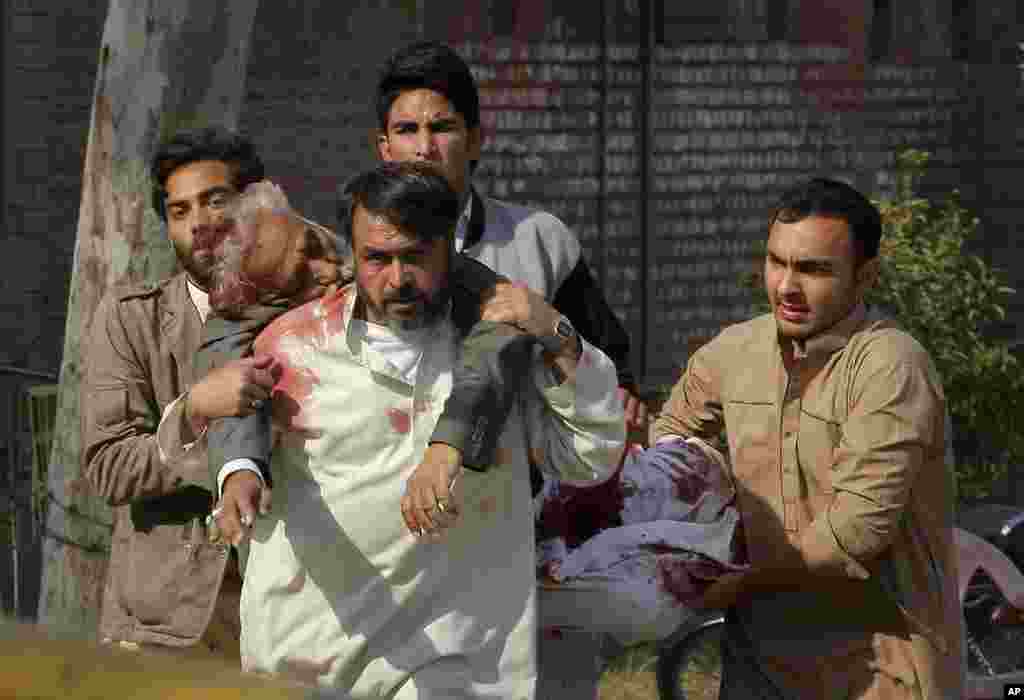 People rush an injured person to the hospital following a suicide attack at a Shi&#39;ite mosque in Peshawar, Feb. 13, 2015.