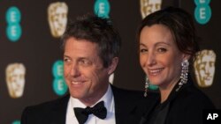 Hugh Grant dan Anna Elisabeth Eberstein berpose di hadapan para fotografer saat tiba untuk menghadiri Britain BAFTA Awards di London, 18 Februari 2018.