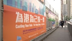 2021年12月19日，香港投票站門前的大幅標語呼籲選民投票。 (美國之音記者 鄧凱欣拍攝)