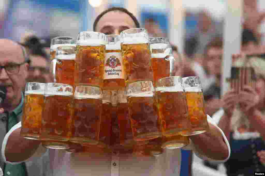 German Oliver Struempfel competes to set a new world record in carrying one liter beer mugs over a distance of 40 m (131 ft 3 in) in Abensberg, Germany.