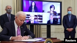U.S. President Joe Biden signs an executive order as part of his administration's plans to fight the coronavirus disease (COVID-19) pandemic during a COVID-19 response event as Dr. Anthony Fauci and COVID-19 czar Jeff Zients listen at the White House in W