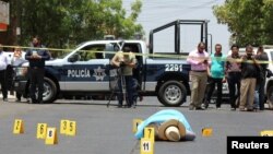 멕시코 범죄조직을 전문으로 취재해 온 자비에르 발데즈 기자가 15일 쿨리아칸 시에서 괴한의 총격을 받고 피살됐다. 수사관들이 사체 옆에서 현장을 수색하고 있다.
