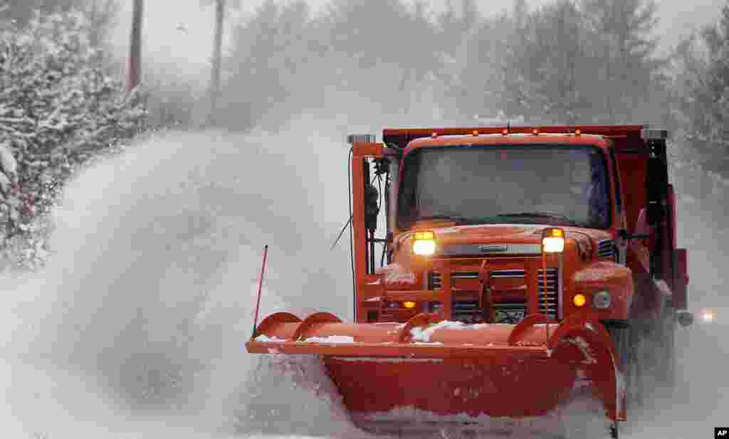 Petugas membersihkan salju dari sebuah jalan utama di kota Henniker, negara bagian New Hampshire, di timur laut wilayah AS, Kamis (2/1). (AP/Jim Cole) 