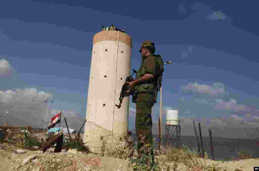 Palestinian Hamas security guard stands near an Egyptian watch tower on the border with Egypt in Rafah, southern Gaza Strip, July 5, 2013. An Egyptian official said the country&#39;s border crossing with Gaza Strip in northern Sinai has been closed indefinitely.