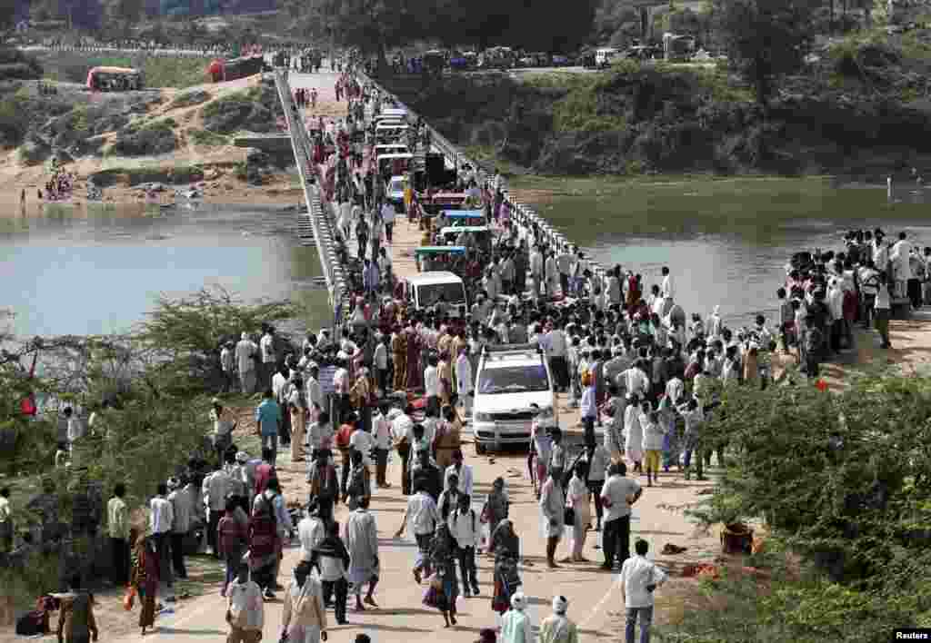 People cross a bridge after a stampede near Ratangarh temple in Datia district in the central Indian state of Madhya Pradesh, Oct. 13, 2013. 