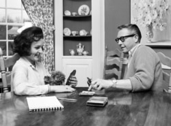 FILE - Betty White and her husband Allen Ludden play a game of cards in their home in Westchester, N.Y., April 29, 1965.