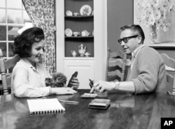 FILE - Betty White and her husband Allen Ludden play a game of cards in their home in Westchester, N.Y., April 29, 1965.