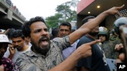 A supporter of newly appointed Sri Lankan prime minister Mahinda Rajapaksa shouts at police officers outside the Petroleum Ministry building in Colombo, Sri Lanka, Oct. 28, 2018. 