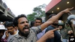A supporter of newly appointed Sri Lankan prime minister Mahinda Rajapaksa shouts at police officers outside the Petroleum Ministry building in Colombo, Sri Lanka, Oct. 28, 2018.