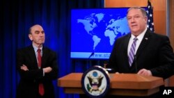 Elliott Abrams, left, listens to Secretary of State Mike Pompeo talk about Venezuela at the State Department in Washington, Jan. 25, 2019. 