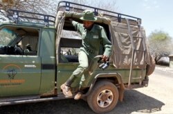 Purity Rakala, anggota Team Lioness, sebuah unit ranger Kenya yang semuanya wanita, turun dari truk pickup patroli di kamp Risa, tempat mereka tinggal karena wabah Covid-19, Kenya, 7 Agustus 2020. (Foto: REUTERS/Njeri Mwangi)