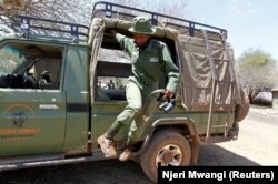 Purity Rakala, anggota Team Lioness, sebuah unit ranger Kenya yang semuanya wanita, turun dari truk pickup patroli di kamp Risa, tempat mereka tinggal karena wabah Covid-19, Kenya, 7 Agustus 2020. (Foto: REUTERS/Njeri Mwangi)