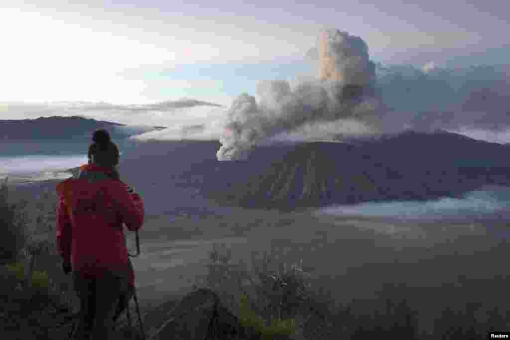 A visitor takes photographs of Mount Bromo, an active volcano and popular tourist destination, in Probolinggo, East Java province, Indonesia, in this photo taken by Antara Foto.