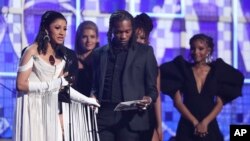 Cardi B, left, accepts the award for best rap album for "Invasion of Privacy" at the 61st annual Grammy Awards, Feb. 10, 2019, in Los Angeles, California. 