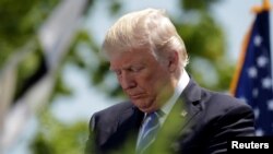 U.S. President Donald Trump bows his head in prayer at the United States Coast Guard Academy Commencement Ceremony in New London, Connecticut, May 17 2017.