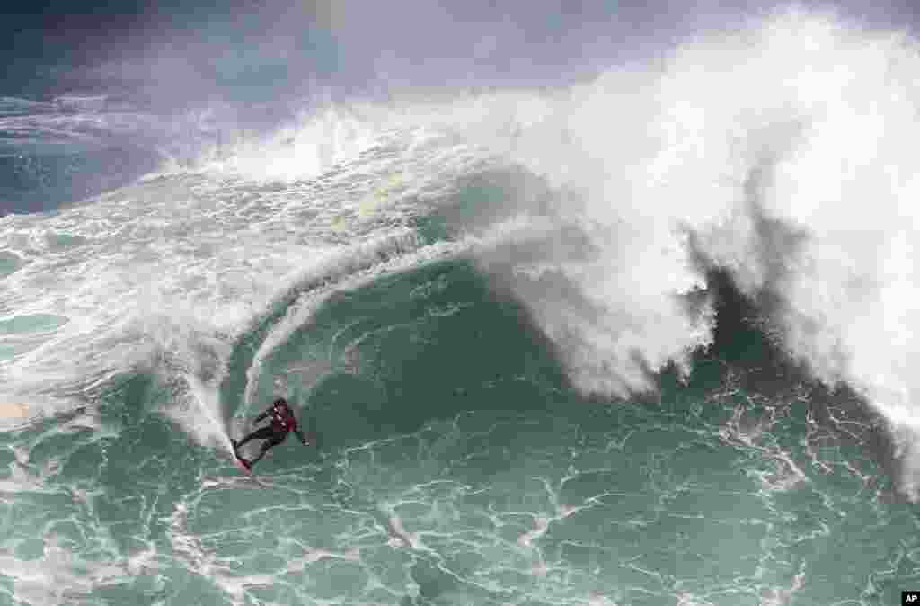 Surfer Axi Muniain from Spain rides a wave during a big wave surfing session at the Praia do Norte, or North beach, in Nazare, Portugal.