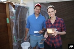FILE - New Zealand Labour Party leader Jacinda Ardern and her partner, Clarke Gayford, paint their fence at home in Auckland, New Zealand, Sept. 23, 2017.