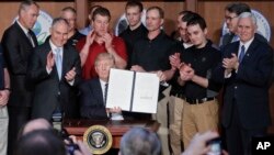 도널드 트럼프 미국 대통령이 28일 환경청에서 '에너지 독립' 행정명령에 서명한 후 광부들과 정부 관계자들의 박수를 받고 있다.