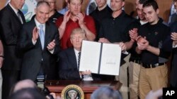 President Donald Trump, accompanied by coal miners and, from left, Interior Secretary Ryan Zinke, Environmental Protection Agency (EPA) Administrator Scott Pruitt, second from right, Energy Secretary Rick Perry, and Vice President Mike Pence, far right, h