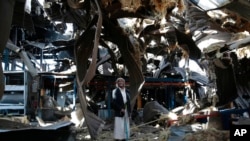 FILE - Massoud Abdullah Azzan, 75, who is a doorkeeper, stands amid the rubble of Alsonidar Group's water pumps and pipes factory after it was hit by Saudi-led airstrikes, in Sanaa, Yemen, Sept. 22, 2016.