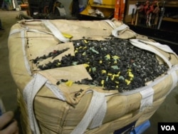 A load of shredded plastic gas tanks, removed from junkyard automobiles, awaits its turn with the plastic-eating monster. (VOA/D. Robison)