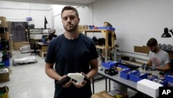 Cody Wilson, founder of Defense Distributed, holds a 3D-printed gun, Aug. 1, 2018, in Austin, Texas. Wilson resigned from the company after being arrested on charges of having sex with an underage girl.