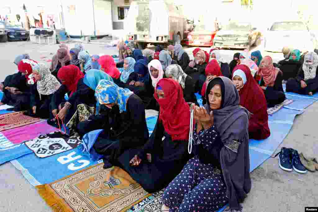 Para migran Muslim melaksanakan salat Idulfitri di pusat penahanan di Tripoli, Libya, 15 Juni 2018.