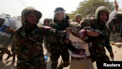 Một công nhân dệt may bị bắt trong cuộc biểu tình ở ngoại ô Phnom Penh.