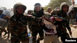 Tentara Kamboja menahan seorang pekerja dalam aksi demonstrasi di Phnom Penh, Kamis (2/1). 