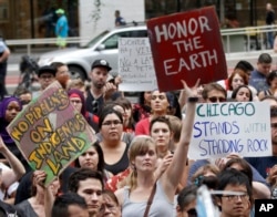 Protesters against the four-state Dakota Access pipeline hold signs during a rally in Chicago, Sept. 9, 2016.