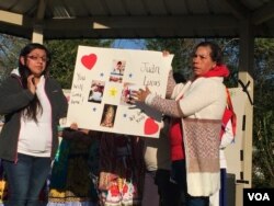At a prayer vigil, family members hold up a poster calling for the return of one of the detained workers. (Photo: Marissa Melton / VOA)